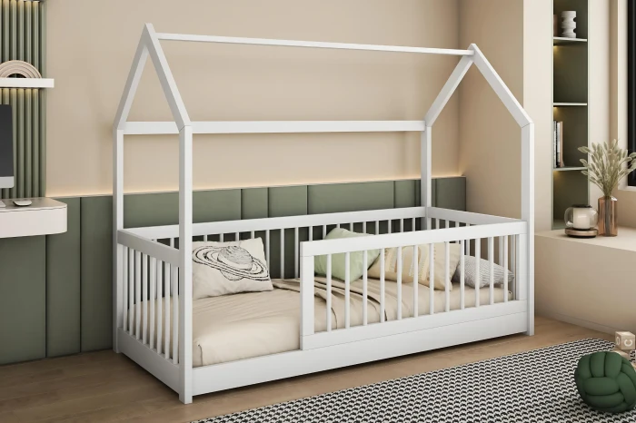 Gemütliches Kinderbett in Hausform in Weiß mit sicherem Rausfallschutz.