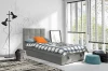 Stilvolles Jugendbett in Grau mit Bettwäsche in einem modern eingerichteten Zimmer mit viel Licht.
