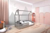 Modernes graues Hausbett im Kinderzimmer mit Berg-Wandtattoo und rosa Schränken.