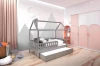 Kinderschlafzimmer mit grauem Haus-Bett, Berg-Wandtattoo und Kleiderschrank in Rosa und Weiß.