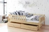Holz-Kinderbett aus Kiefer mit Rausfallschutz und Dekokissen in wohnlicher Atmosphäre.