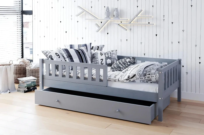 Graues Kinderbett mit Schublade und Kissen in modern dekoriertem Kinderzimmer.