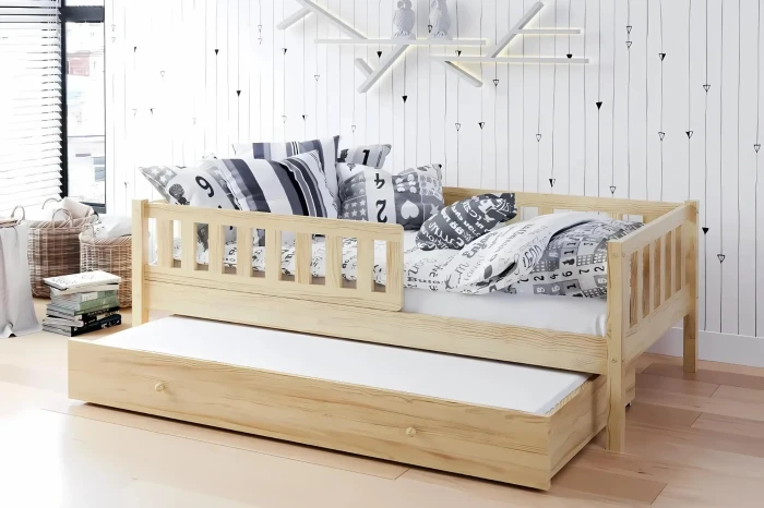 Massives Kinderbett in Naturholz-Optik mit zweiter Schlafgelegenheit zum Ausziehen.