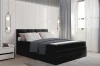 Elegantes Boxspringbett in Schwarz mit gepolstertem Kopfteil und Kissen in modernem Schlafzimmer.
