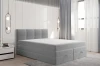 Hellgraues Boxspringbett in modernem Schlafzimmer mit dekorativem Kopfteil und viel Stauraum.