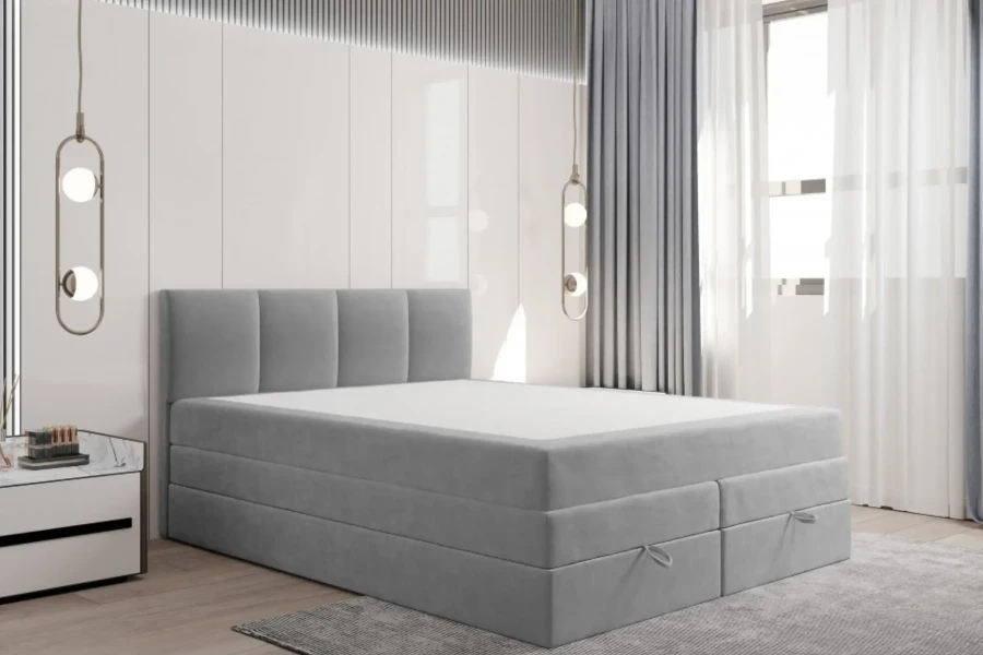 Hellgraues Boxspringbett in modernem Schlafzimmer mit dekorativem Kopfteil und viel Stauraum.