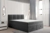 Anthrazitfarbenes Boxspringbett mit gepolstertem Kopfteil in einem hellen, modernen Schlafzimmer.
