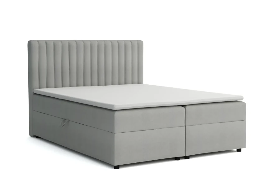 Elegantes hellgraues Boxspringbett mit vertikal gestepptem Kopfteil.