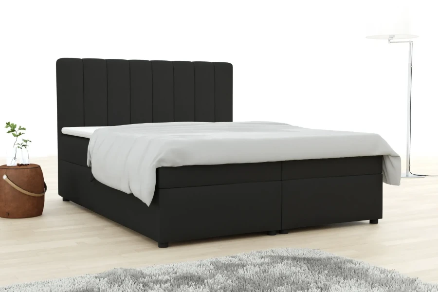 Schwarzes Boxspringbett mit vertikal gestepptem Kopfteil in modernem Schlafzimmer.