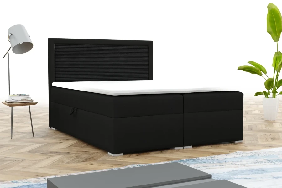 Elegantes schwarzes Boxspringbett mit weißem Topper in modernem Zimmer mit Designerlampe und Pflanze.
