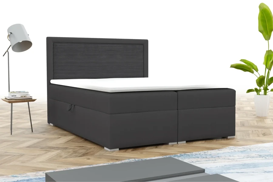 Modernes Boxspringbett in Anthrazit mit dekorativem Kopfteil im Schlafzimmer.