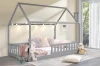 Graues Kinderhausbett gemütlich dekoriert mit Lichterkette, Kissen und Kuscheltieren.