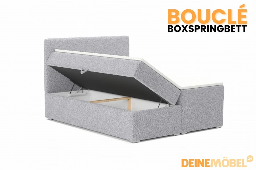 Graues Bouclé Boxspringbett mit offenem Bettkasten für praktischen Stauraum unter dem Bett.