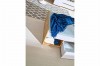 Jugendbett mit Stauraum, blauer Decke und gemustertem Teppich im modernen Zimmer.