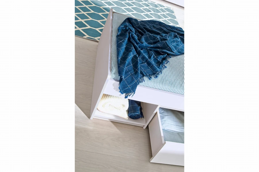Weißes Jugendbett mit offenem Regalfach und Schublade für mehr Ordnung.
