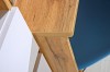 Detailaufnahme einer abgerundeten Schreibtischplatte in Eiche-Optik mit weißen Elementen.