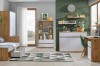 Helles Jugendzimmer in Eiche-Weiß-Optik mit Bett inklusive Bettkasten, Schreibtisch und geometrischem Teppich.