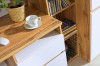 Detailansicht eines Schreibtisches mit Kaffeetasse, weißen Fronten und Holzmaserung.