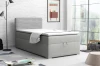 Modernes Jugendzimmer mit grauem Boxspringbett, Skateboard und dekorativer Backsteinwand.
