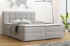 Modernes Boxspringbett in Grau mit gestepptem Kopfteil in hellem Schlafzimmer.