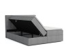 Graues Boxspringbett mit praktischem seitlich aufklappbarem Bettkasten für extra Stauraum.