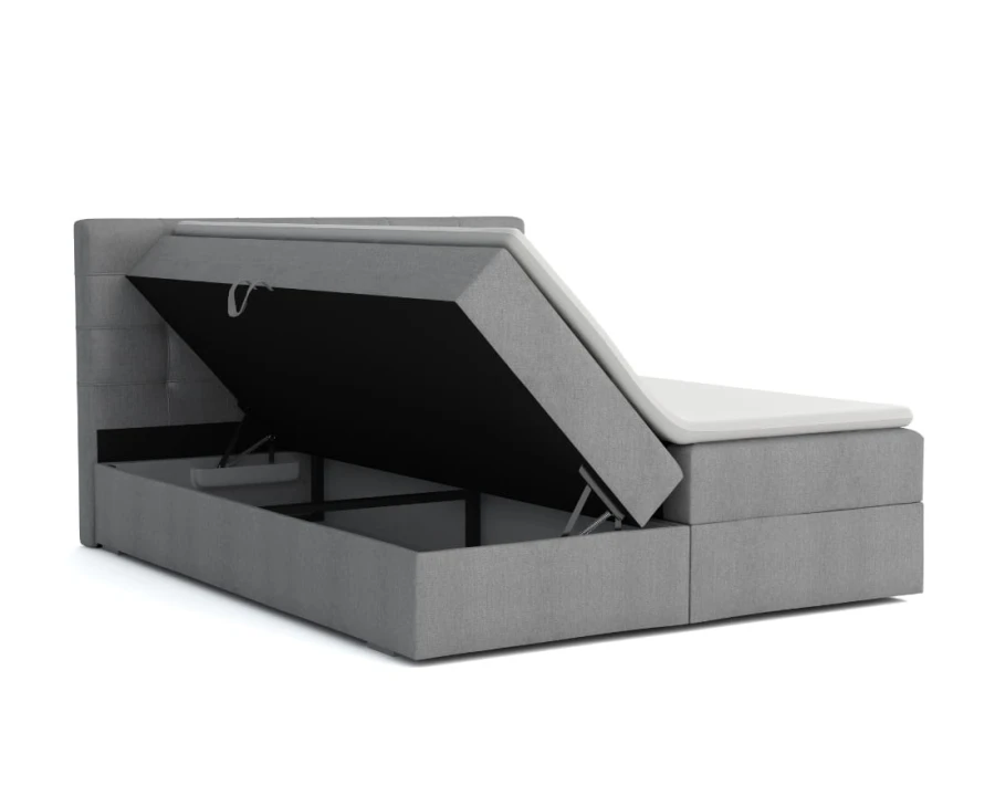 Graues Boxspringbett mit praktischem seitlich aufklappbarem Bettkasten für extra Stauraum.