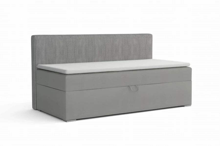 Grey upholstered bed with bed storage, ribbed headboard and white topper.
