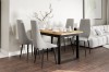 Dining table set with wooden top and 4 light grey velvet chairs in modern dining room.