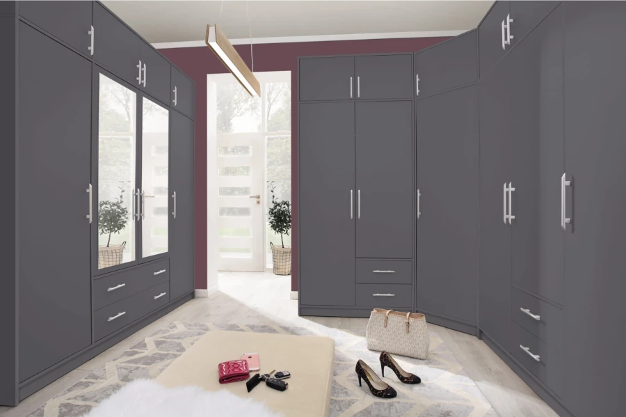 Moderner grauer Kleiderschrank mit Spiegeltüren und silbernen Griffen im begehbaren Ankleidezimmer.
