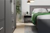 Modernes Schlafzimmer-Set in Anthrazit mit Kleiderschrank, passendem Nachttisch und grauem Polsterbett.