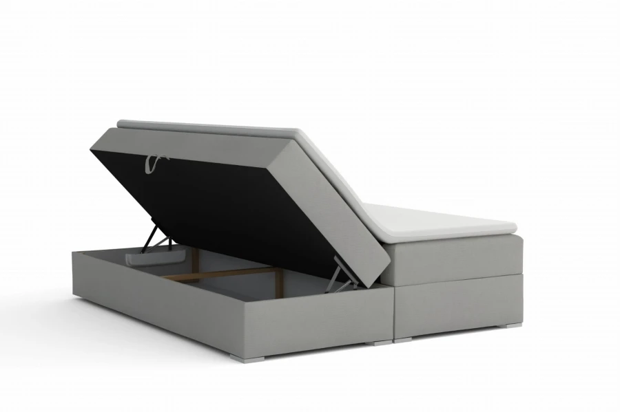 Graues Boxspringbett mit offenem Bettkasten für Stauraum.