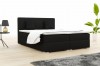 Black boxspring bed with white bed linen and two cushions.