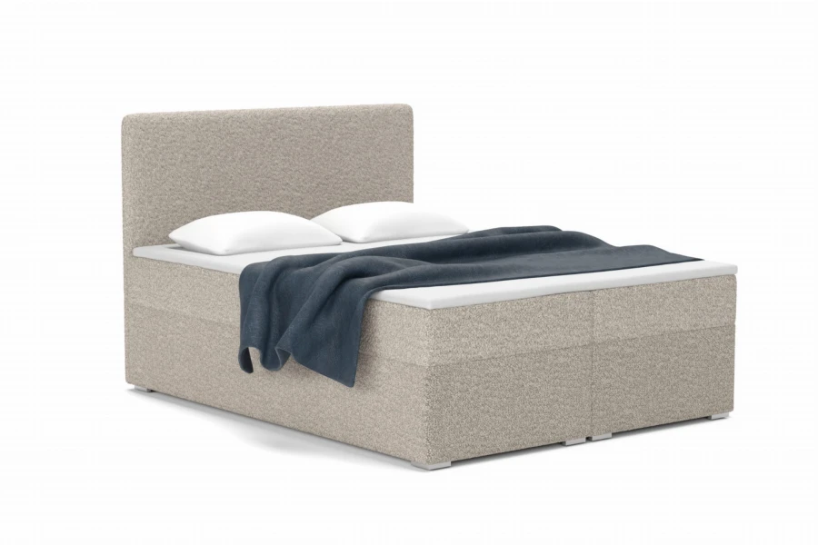 Modernes Boxspringbett in Beige mit Stoffbezug, Kissen und blauer Decke.