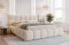 Modernes Bett mit weicher Bouclé-Polsterung in Beige in einem stilvoll eingerichteten Raum.