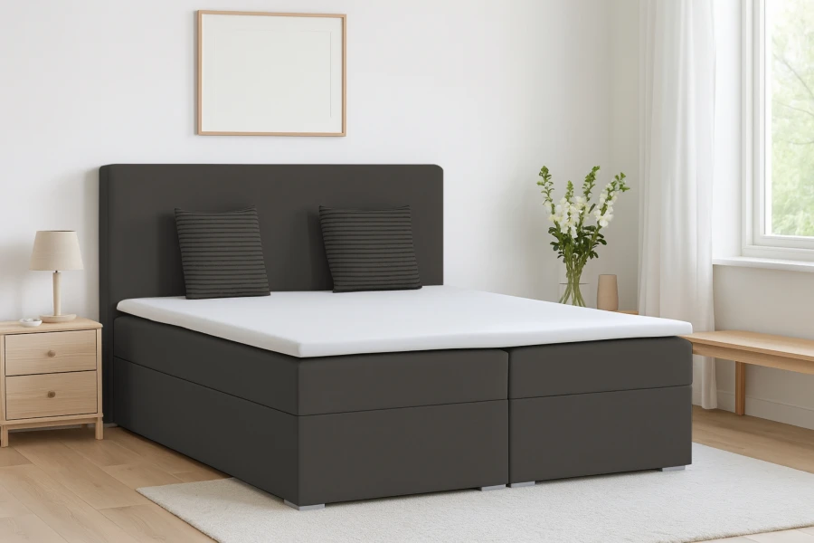 Dunkelgraues Boxspringbett in modernem Schlafzimmer mit hellem Teppich.