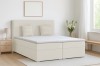 Beiges Boxspringbett in hellem, skandinavisch eingerichtetem Schlafzimmer.