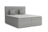 Hellgraues Boxspringbett mit zwei gestreiften Zierkissen auf weißem Hintergrund.