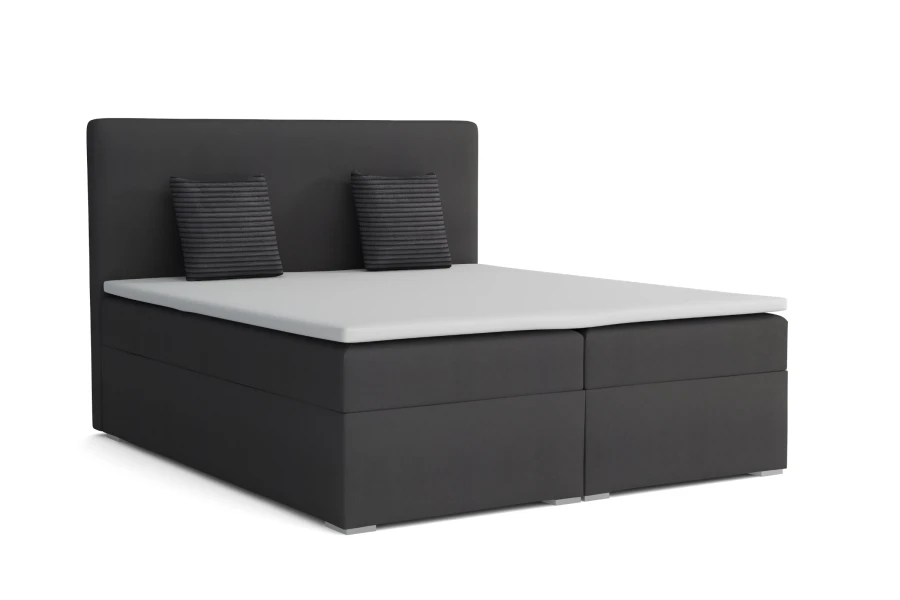 Modernes Boxspringbett in Anthrazit mit weißem Topper und zwei Zierkissen auf weißem Hintergrund.