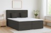 Modernes Boxspringbett in Anthrazit mit weißem Topper in einem hell eingerichteten Schlafzimmer.