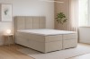 Beiges Boxspringbett in gemütlichem Schlafzimmer-Ambiente mit Pflanze und Beistelltisch