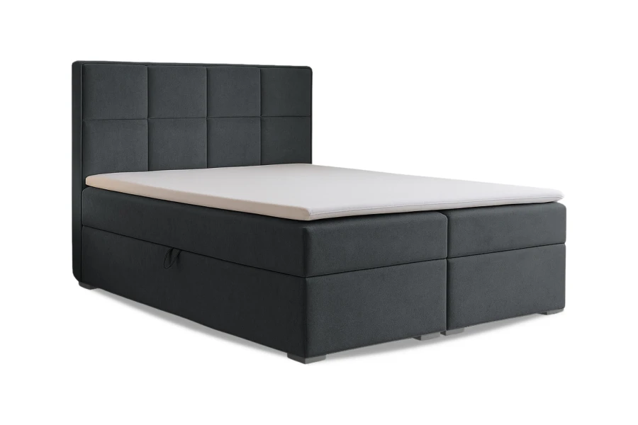 Dunkelgraues Boxspringbett mit quadratisch gestepptem Kopfteil vor weißem Hintergrund.