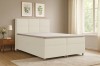 Cremefarbenes Boxspringbett in einem gemütlich eingerichteten Schlafzimmer.