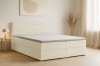 Modernes Boxspringbett mit beigem Cord-Bezug in einem hellen, minimalistischen Schlafzimmer.