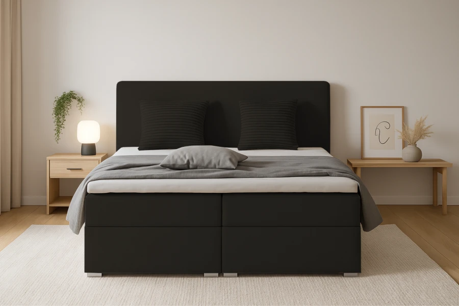 Schwarzes Boxspringbett Bello von vorne mit Kissen und Tagesdecke.