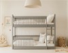 Front view of a grey children's bunk bed made of solid wood in a bright children's room.