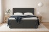 Modernes Bouclé Boxspringbett in Dunkelgrau mit stilvollen Nachttischen und Beleuchtung.