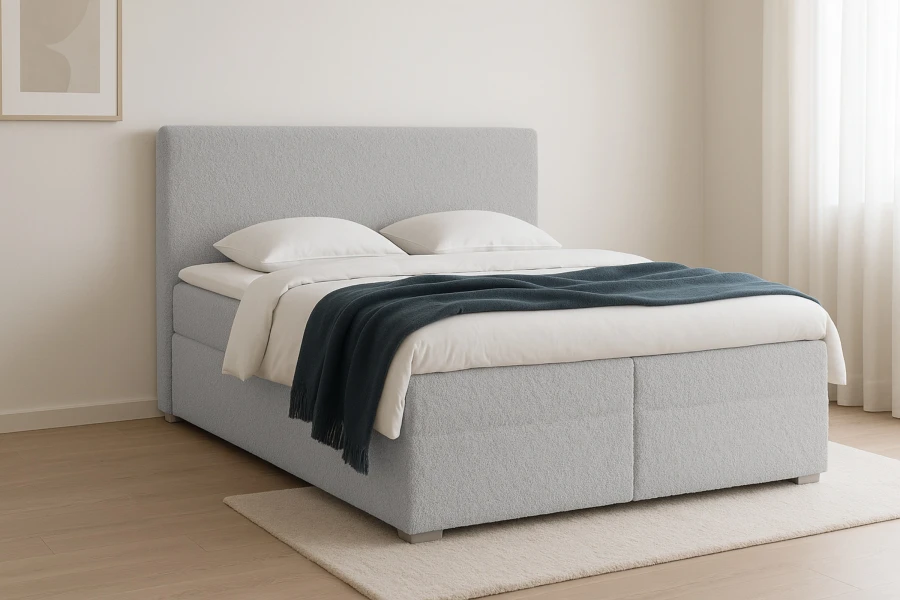 Modernes hellblaues Bouclé Boxspringbett mit dunkler Kuscheldecke im Schlafzimmer