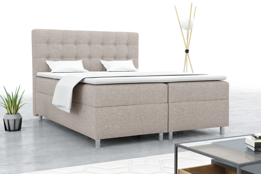 Eingerichtetes Schlafzimmer mit beigem Boxspringbett und Dekoration.
