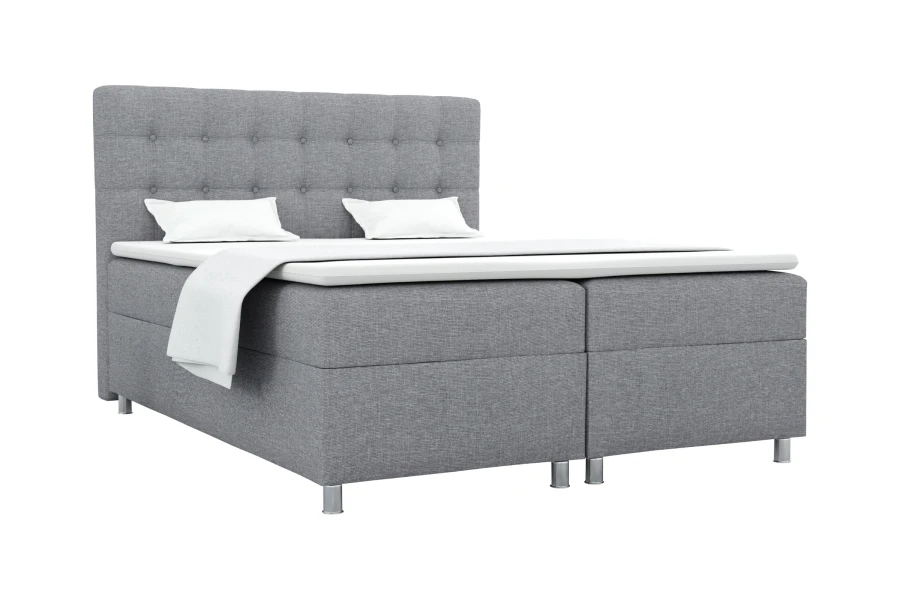 Modernes Boxspringbett in Grau mit gepolstertem Kopfteil und weißen Kissen vor weißem Hintergrund.