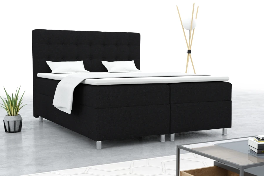 Schwarzes Boxspringbett in stilvollem Schlafzimmer-Ambiente mit Lampe und Zimmerpflanze.